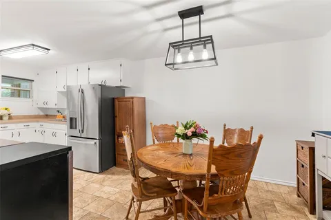 a kitchen with stainless steel appliances kitchen island granite countertop a dining table and chairs