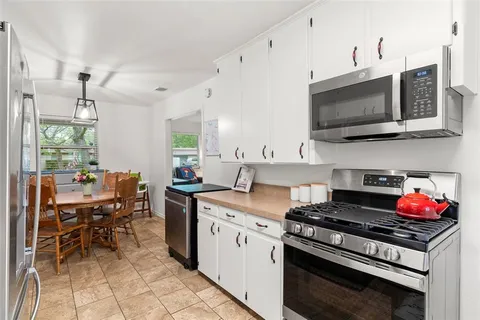 a kitchen with stainless steel appliances a stove a sink and a microwave
