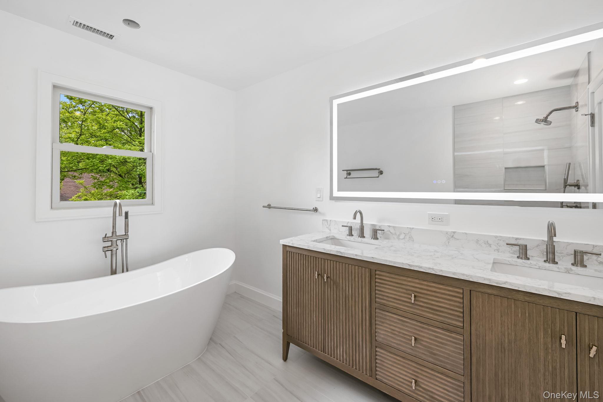 24 Country Road Mamaroneck, NY 10543 - Photo 18 of 37 a bathroom with a granite countertop sink mirror and bathtub