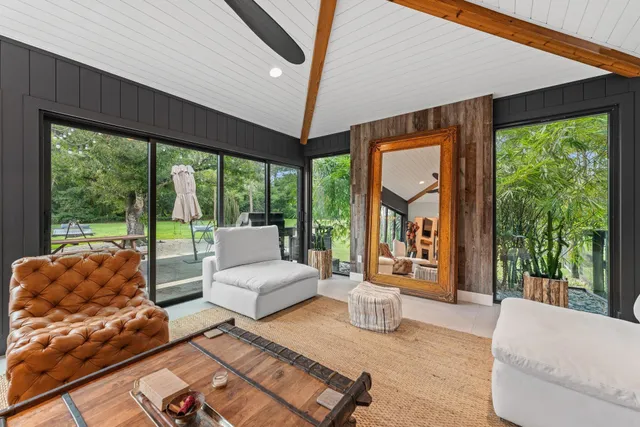 a living room with furniture a flat screen tv and a large window
