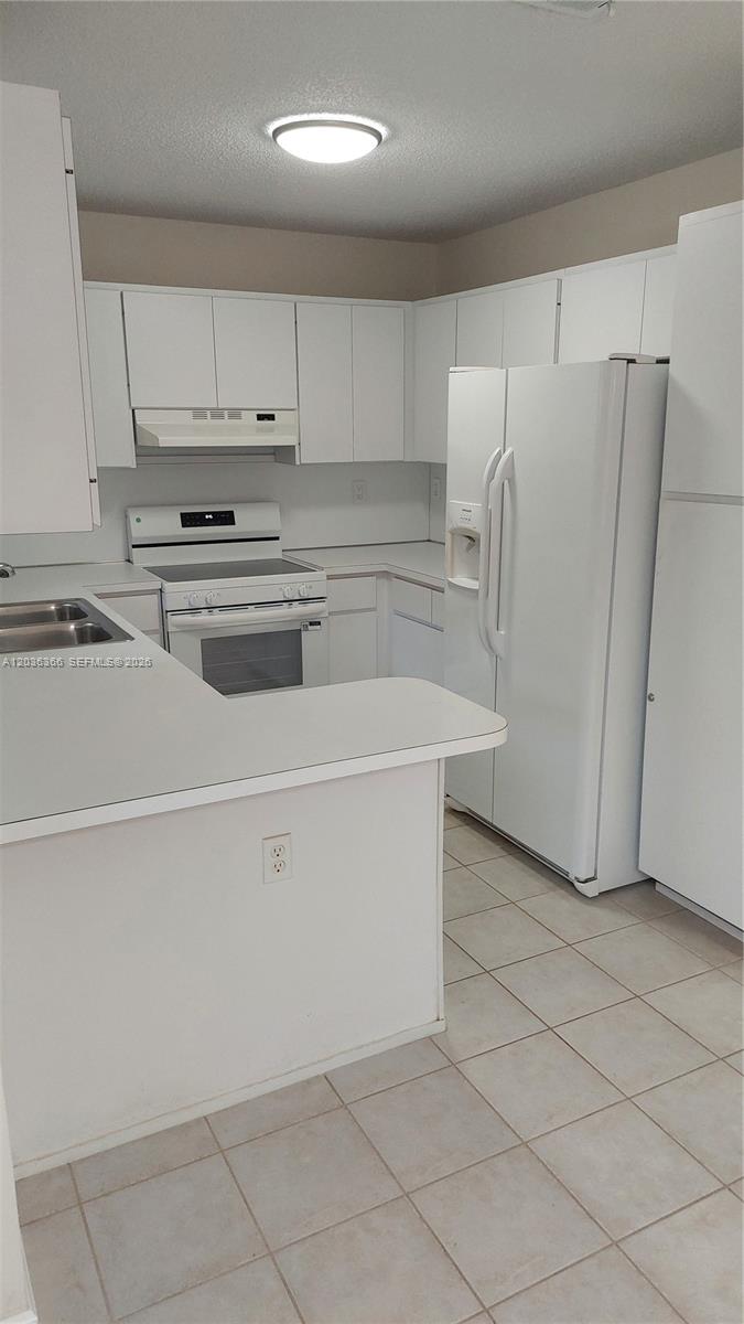 7083 Southwest 158th Court Miami, FL 33193 - Photo 8 of 22 a white refrigerator freezer sitting inside of a kitchen