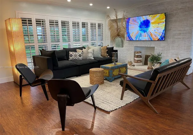 a living room with furniture a flat screen tv and a floor to ceiling window