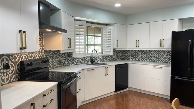 a kitchen with granite countertop a sink stove and refrigerator
