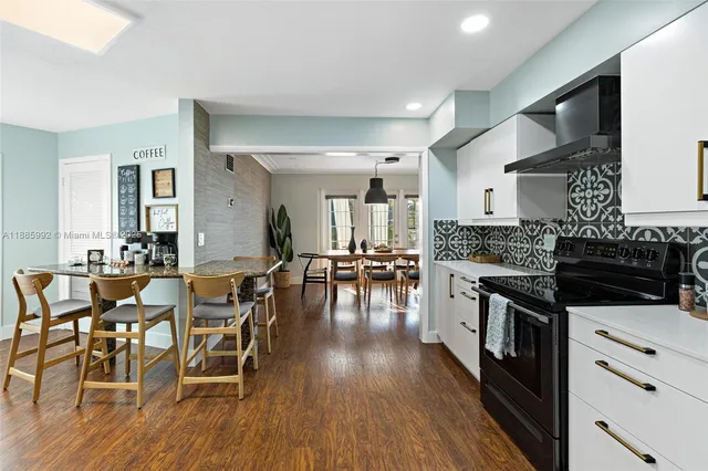 a kitchen with stainless steel appliances wooden floors and wooden cabinets