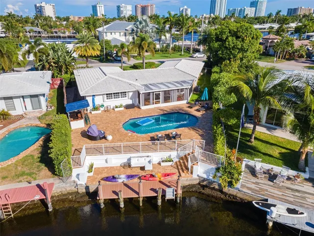 an aerial view of a house with a swimming pool patio and outdoor seating