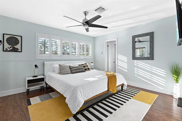 a bedroom with a bed and wooden floor