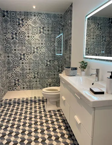 a bathroom with a sink toilet and mirror