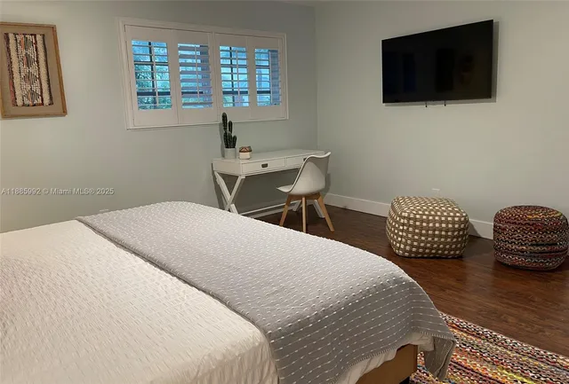 a bedroom with a bed a mirror and a flat screen tv