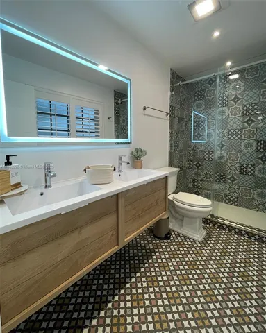 a bathroom with a double vanity sink toilet and mirror
