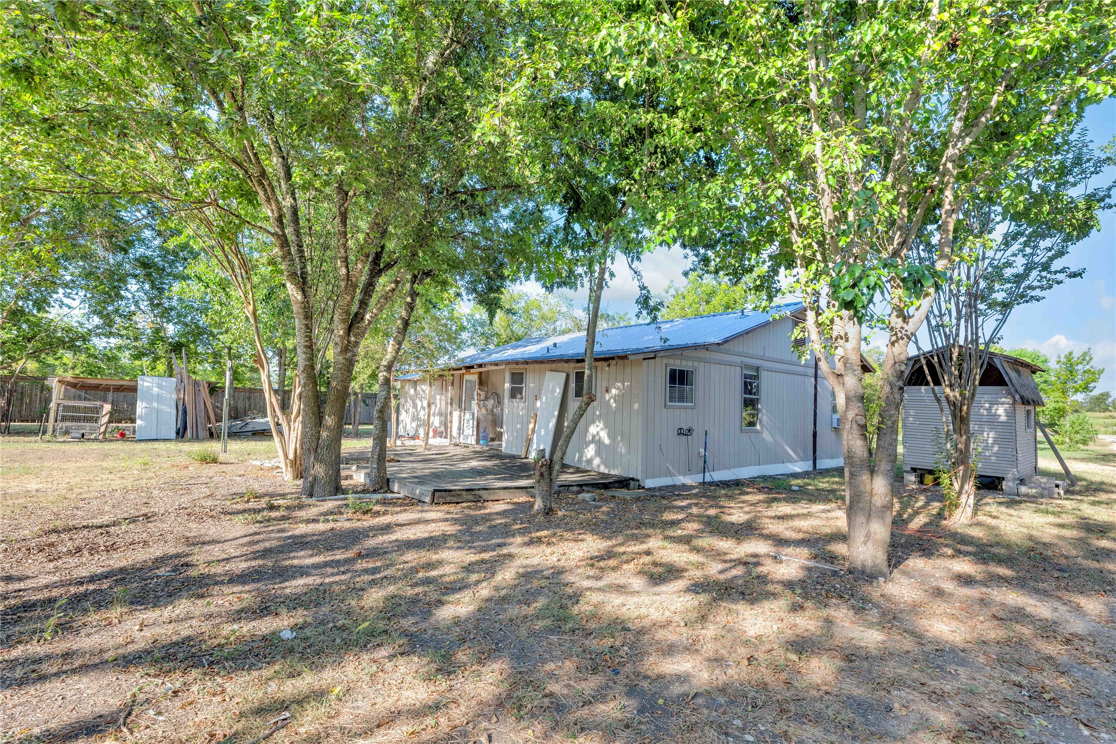 20235 Engelmann Lane Manor, TX 78653 - Photo 18 of 34 Rear view of property with a shed, a metal roof, and a deck