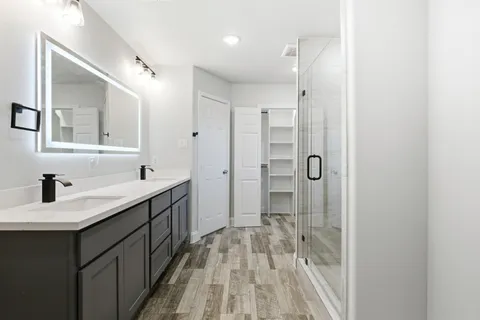 a spacious bathroom with a shower sink and mirror