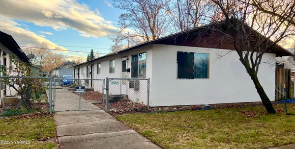 a white house that has tree in front of it