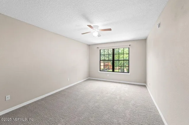 an empty room with closet and windows