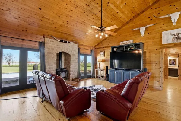 a living room with furniture a flat screen tv and a floor to ceiling window