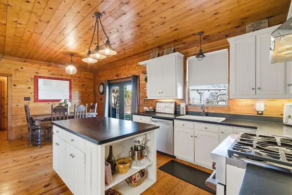 a kitchen with stainless steel appliances a sink a stove and a wooden floors