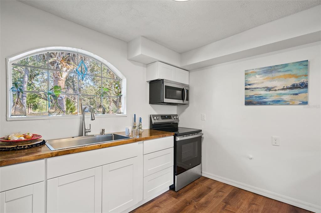 1524 Indian Bay Road Hernando Beach, FL 34607 - Photo 9 of 48 a kitchen with stainless steel appliances granite countertop a stove a sink and a microwave