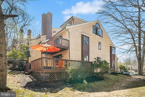 a view of a white house with a small yard and wooden fence