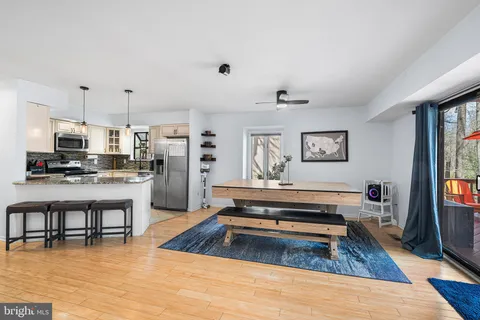 a living room with stainless steel appliances furniture and a kitchen view