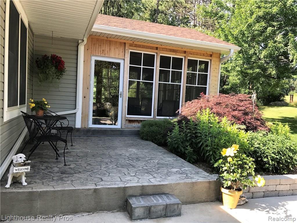 7150 Denton Hill Road Fenton, MI 48430 - Photo 4 of 47 Stamped concrete patio runs inside the covered porch...dog inside porch not included!