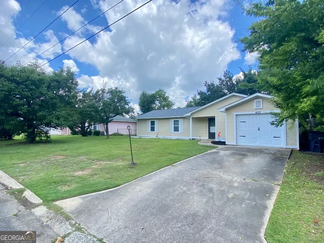 a view of a house with a big yard and large trees