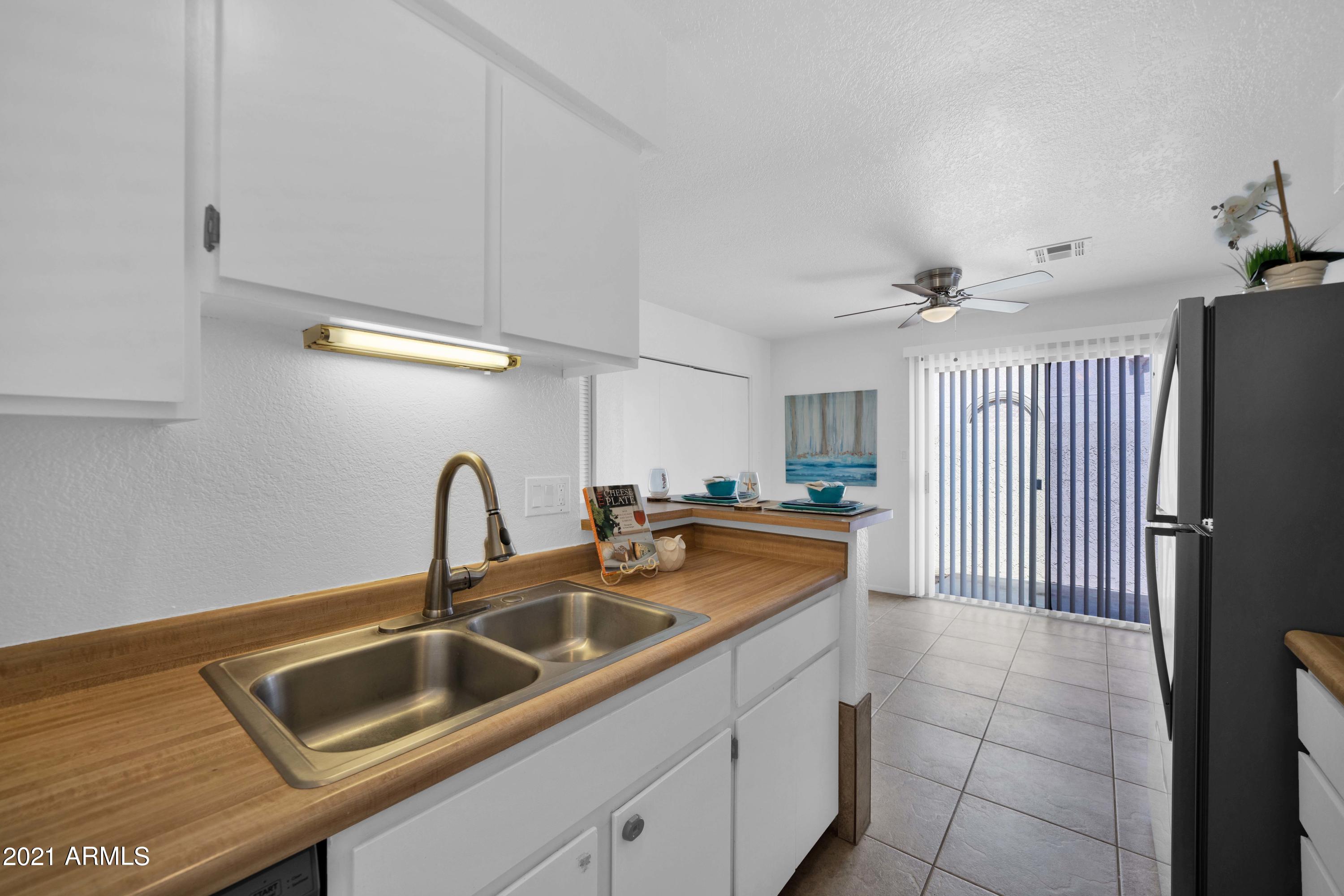 97 North Cooper Road, Unit 104 Chandler, AZ 85225 - Photo 12 of 27 a kitchen with a sink and a refrigerator