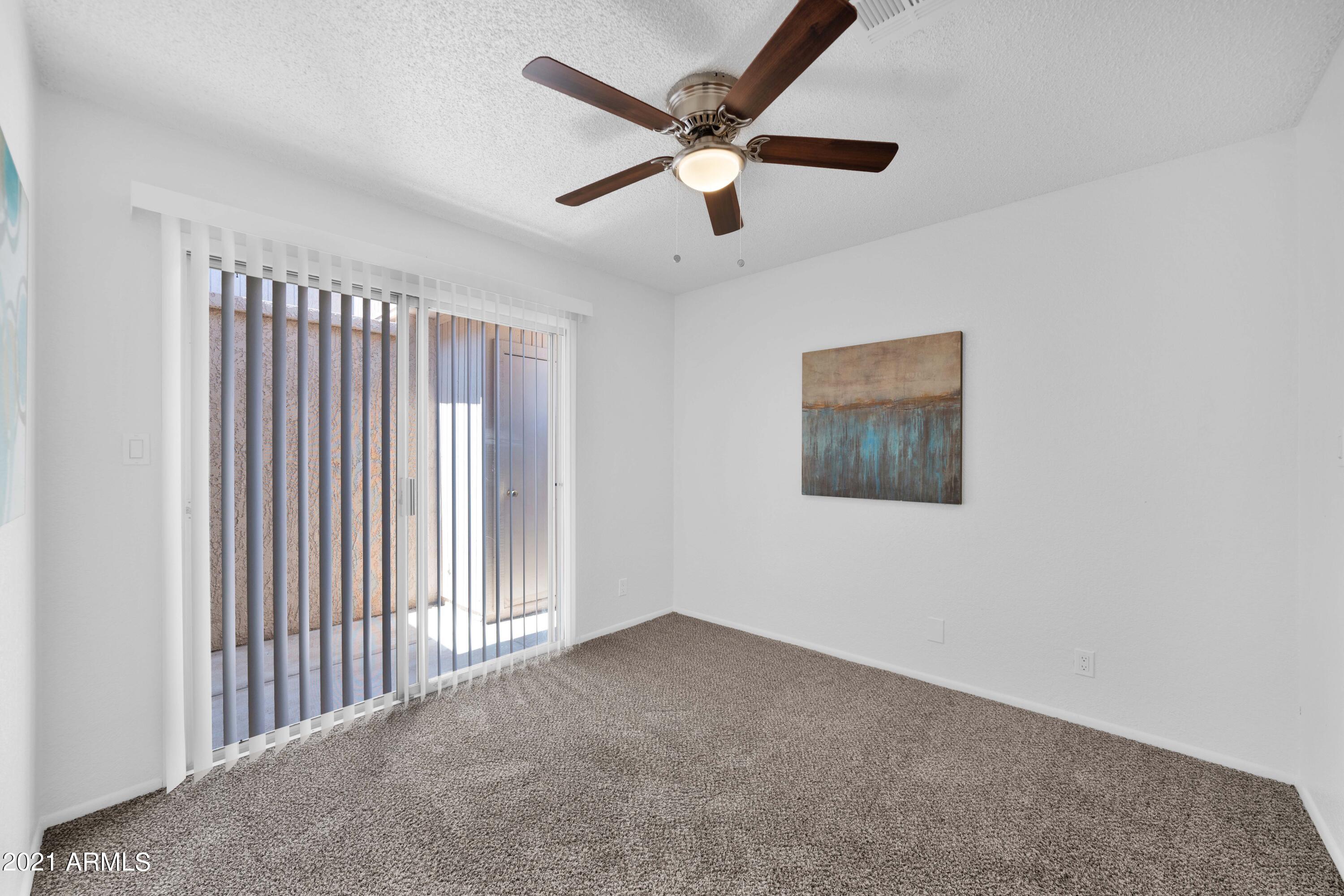 97 North Cooper Road, Unit 104 Chandler, AZ 85225 - Photo 18 of 27 an empty room with a ceiling fan and windows