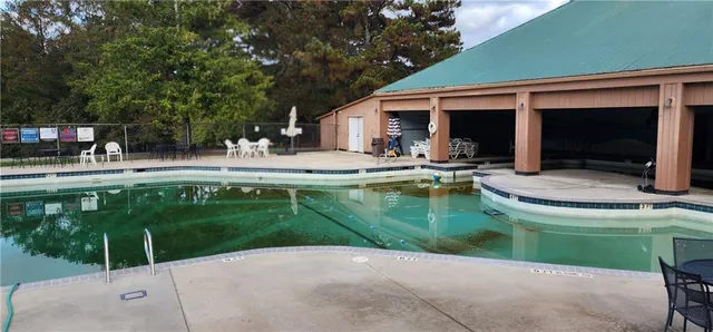 a house view with swimming pool and outdoor seating