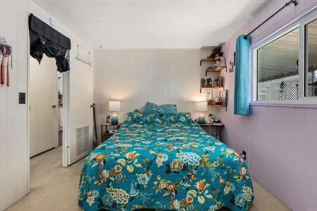 a bedroom with a bed and a painting on the wall