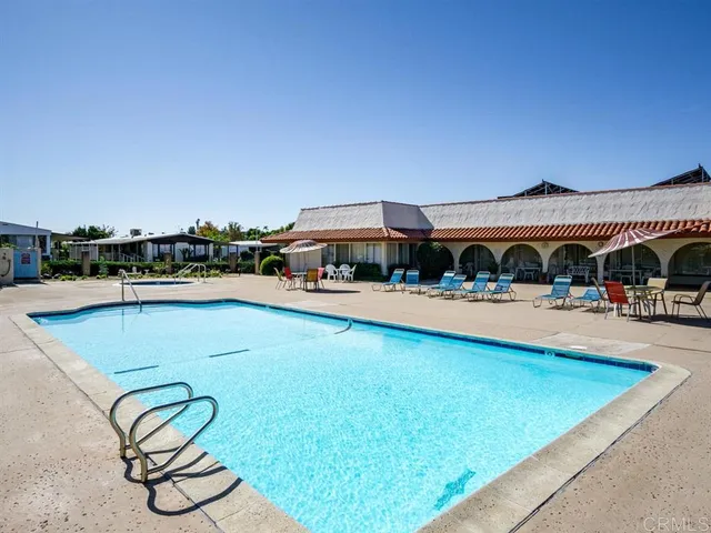 a view of swimming pool with outdoor seating and yard in back