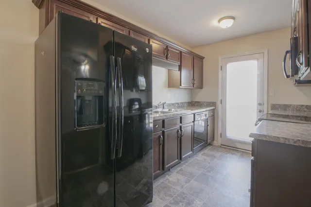 a kitchen with stainless steel appliances granite countertop a refrigerator and a stove
