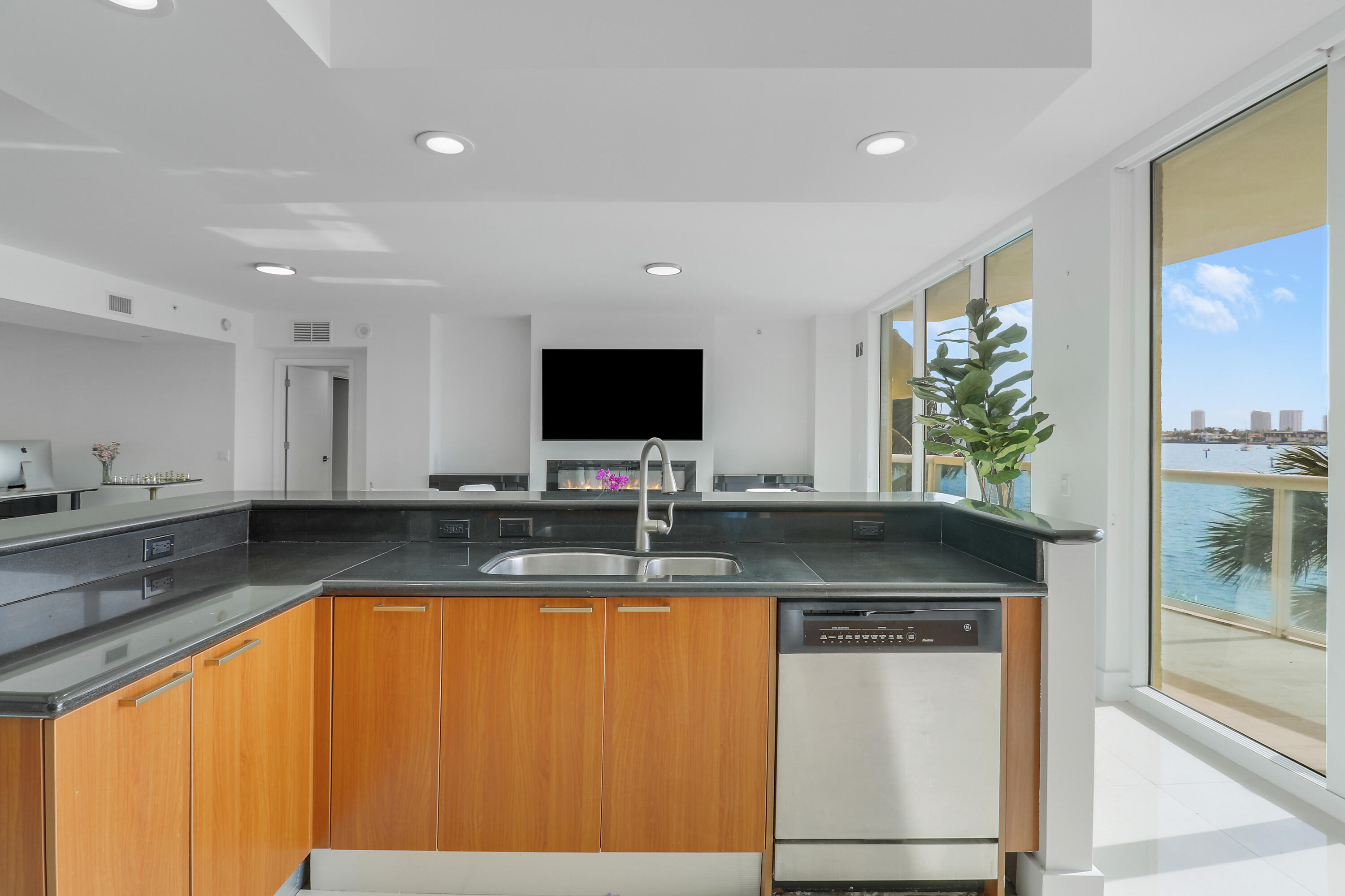 2640 Lake Shore Drive, Unit 307 Riviera Beach, FL 33404 - Photo 16 of 44 a kitchen with granite countertop a sink and a stove top oven