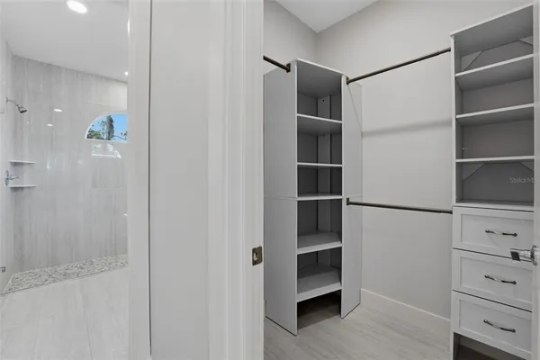 a view of walk in closet with empty racks