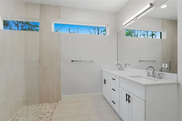 a spacious bathroom with double vanity and mirrors