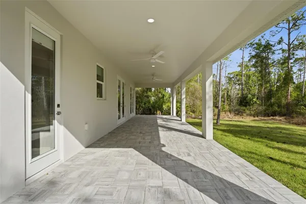 a view of a porch with wooden floor and a yard