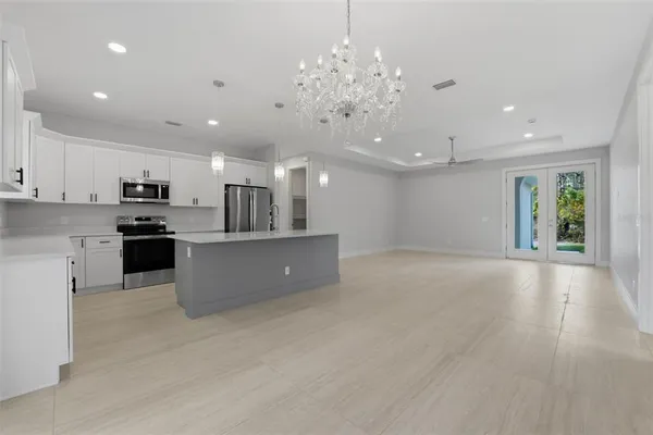 a view of kitchen with kitchen island stainless steel appliances sink refrigerator and microwave