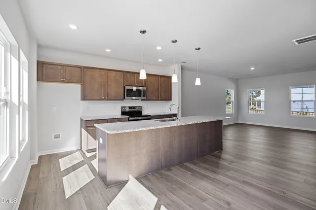 a kitchen with stainless steel appliances granite countertop a sink stove and microwave