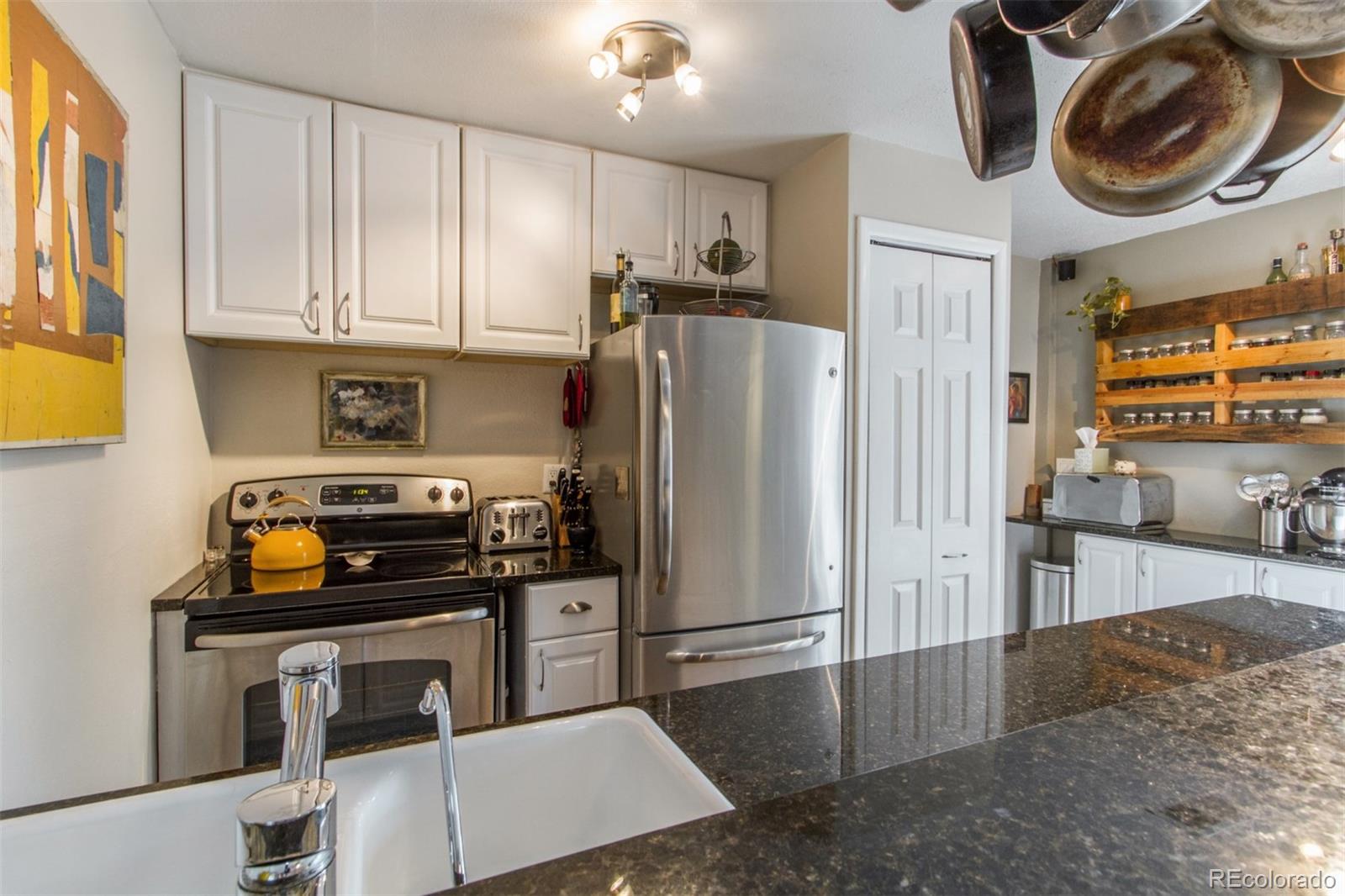 3705 Zuni Street Denver, CO 80211 - Photo 7 of 15 a kitchen with stainless steel appliances granite countertop a refrigerator a stove and a sink with cabinets