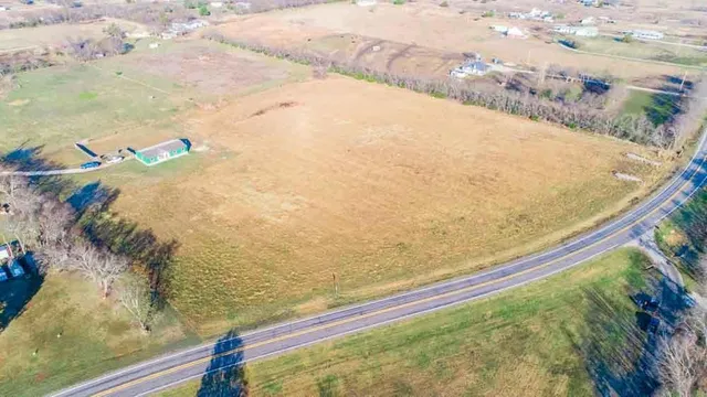 a kitchen with stainless steel appliances granite countertop a refrigerator a sink dishwasher a stove and a dining table with wooden floor
