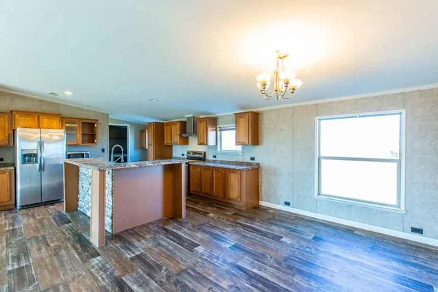 a kitchen with stainless steel appliances granite countertop wooden floors and wooden cabinets
