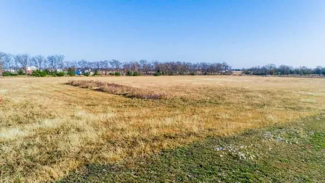 a view of a house with a big yard and large trees
