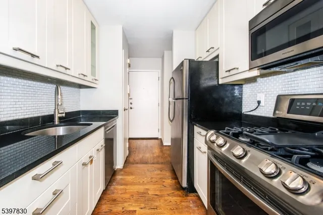 a kitchen with stainless steel appliances granite countertop a stove a refrigerator and a microwave