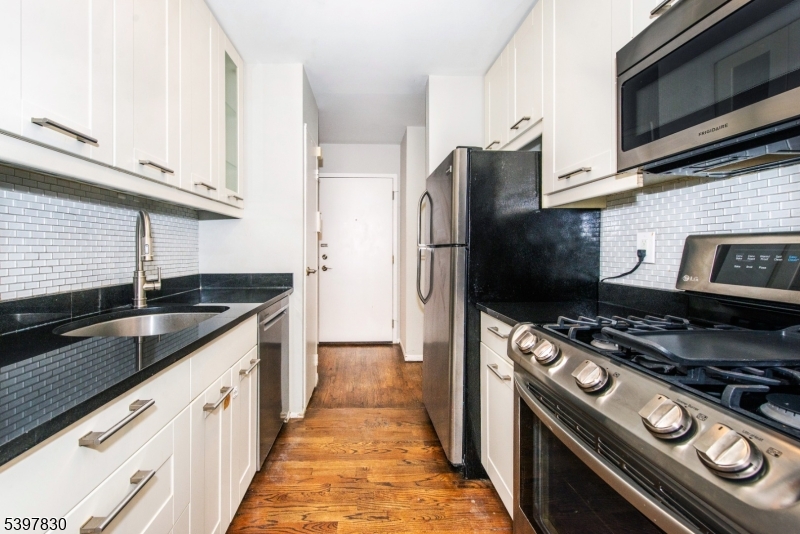 25 River Road, Unit A14 Nutley, NJ 07110 - Photo 12 of 21 a kitchen with stainless steel appliances granite countertop a stove a refrigerator and a microwave