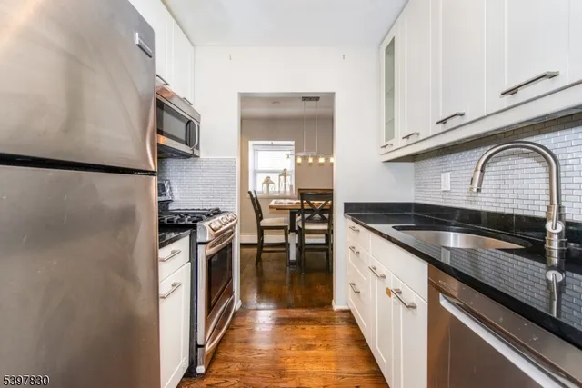 a kitchen with granite countertop a sink and stainless steel appliances