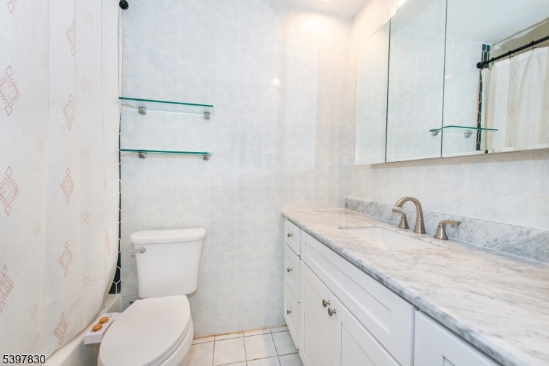 25 River Road, Unit A14 Nutley, NJ 07110 - Photo 19 of 21 a bathroom with a granite countertop toilet sink and mirror