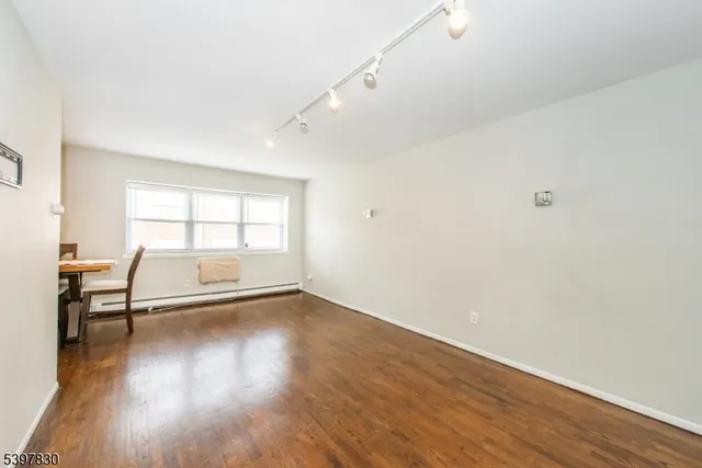 a view of a room with wooden floor and a window