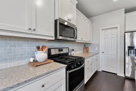 a kitchen with stainless steel appliances granite countertop cabinets and a stove top oven