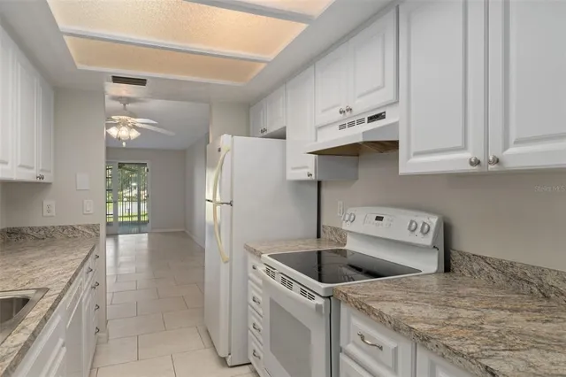 a kitchen with granite countertop a sink and a stove top oven
