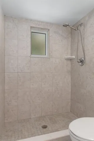 an empty room with windows and ceiling fan