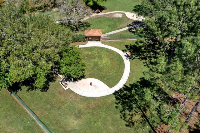 an aerial view of residential house with outdoor space and trees all around