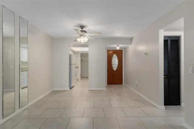 a view of a hallway with a chandelier fan and windows